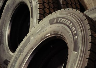 A stack of new Triangle brand heavy-duty commercial truck tires leaning against a wall in a shop